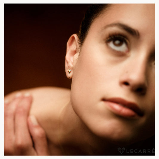 Earrings in gold with a cross set in black diamonds.