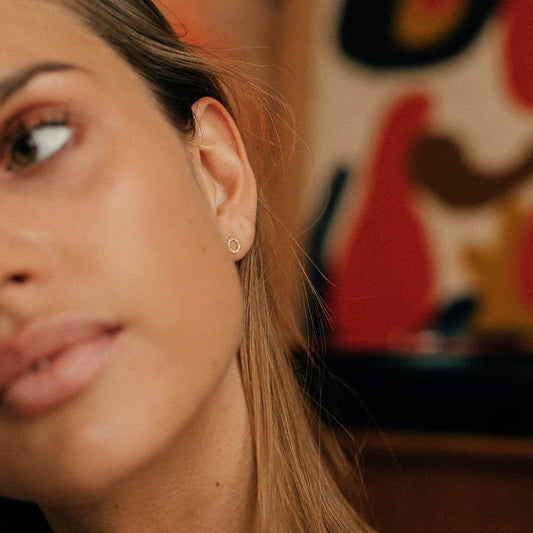 Gold earrings with a diamond hoop.